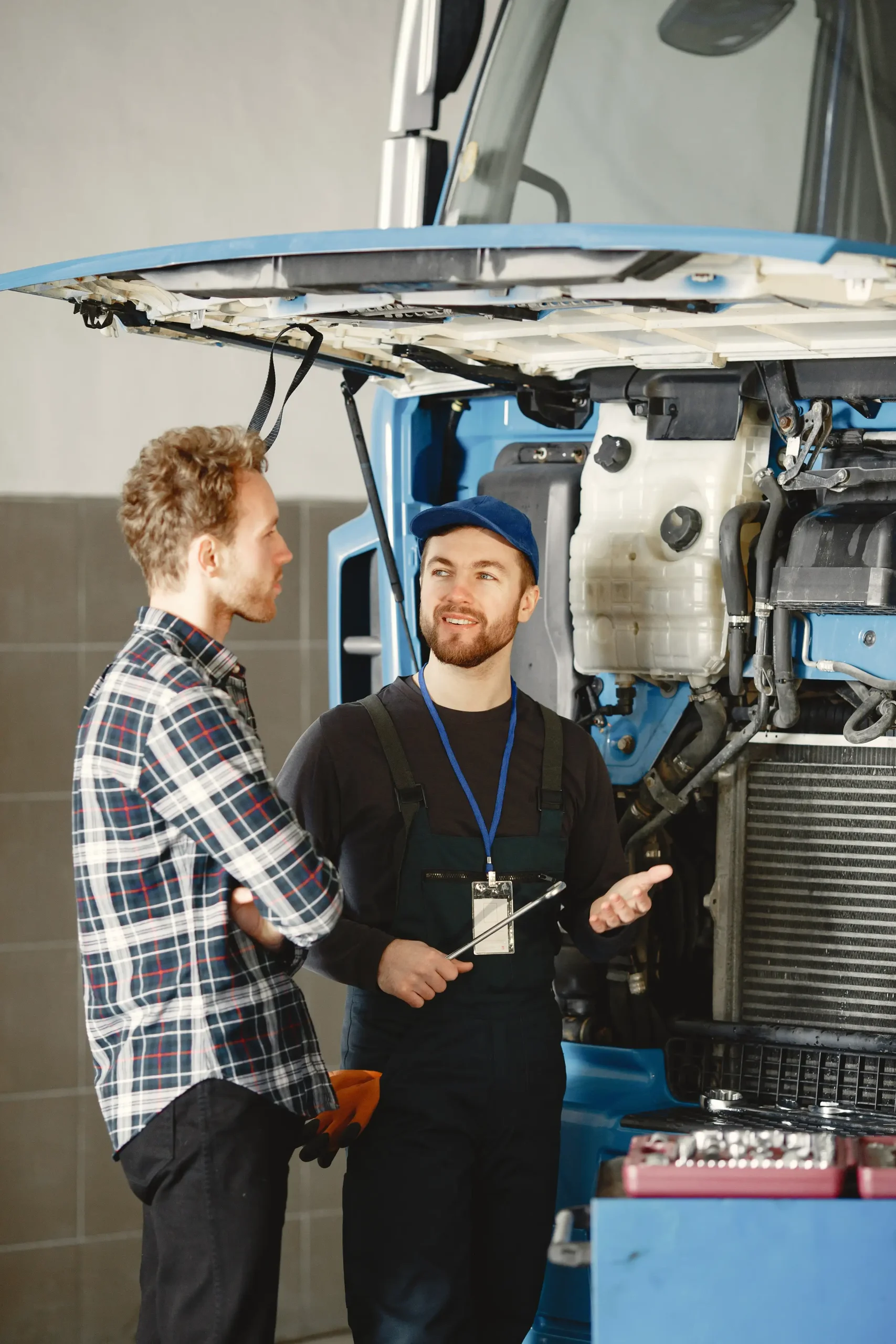 A customer and the mechanic discussing the problem of the trailer truck.