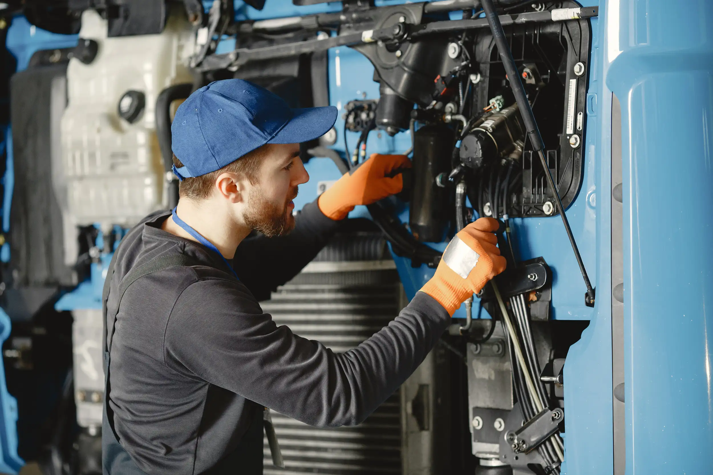 A worker checks the quality of the wires and cable of the truck.