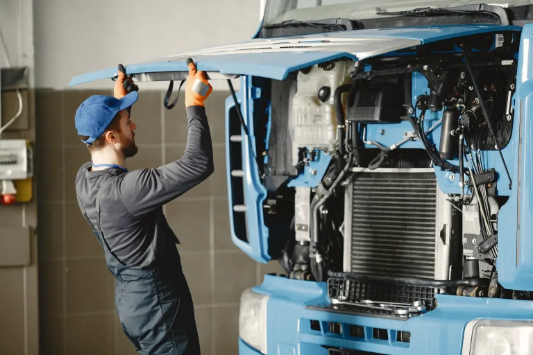 A mechanic opening up the hood of the truck for inspection.