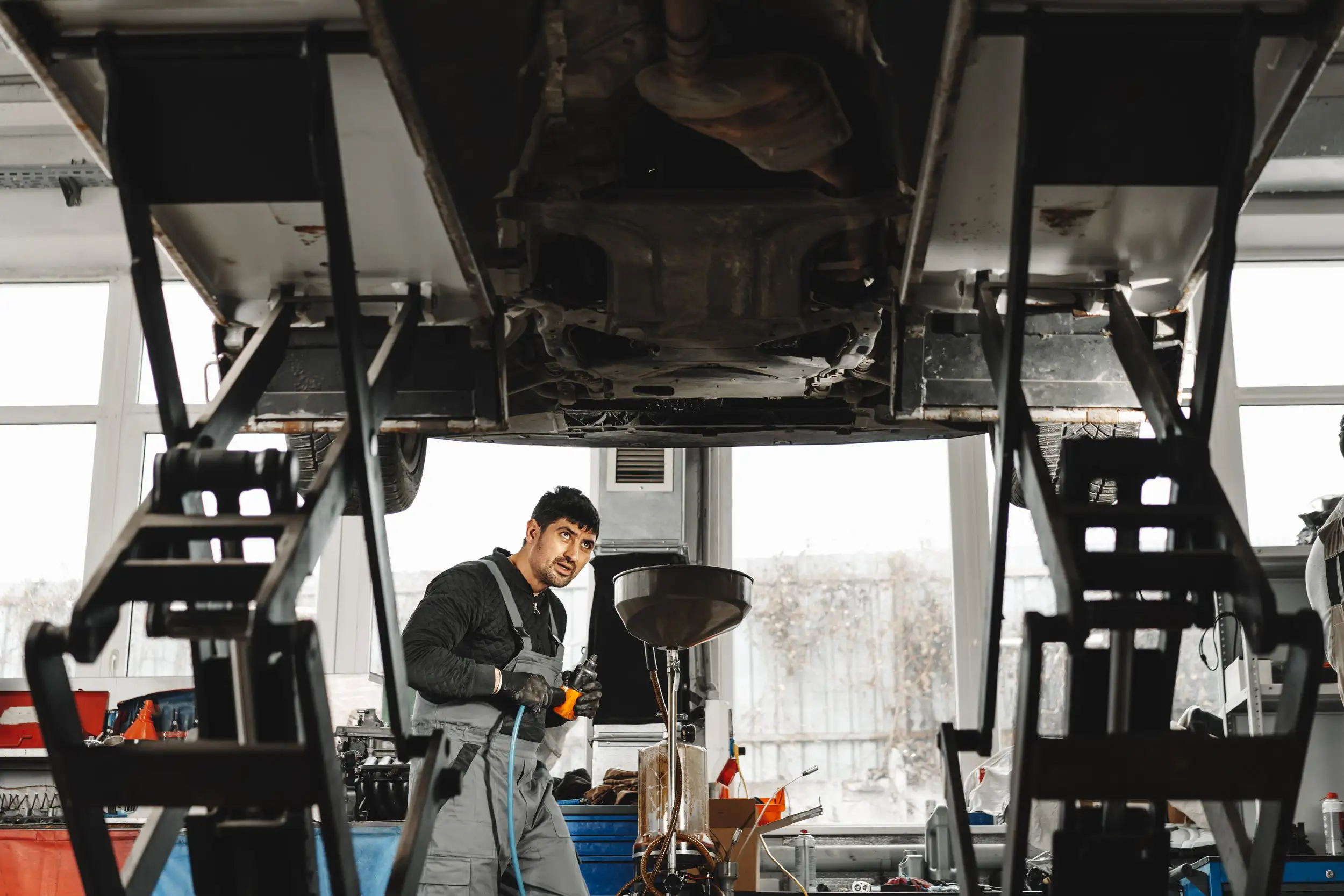 A mechanic working under the truck for engine oil problem.
